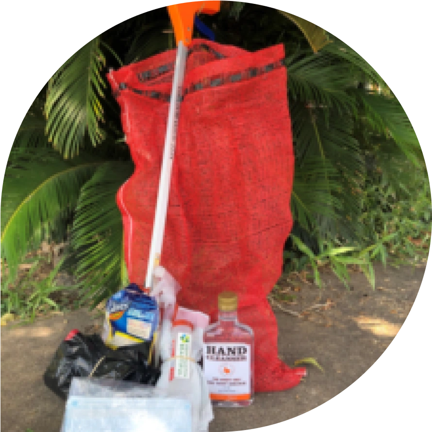 A red trash bag with several pieces of trash in front of it.