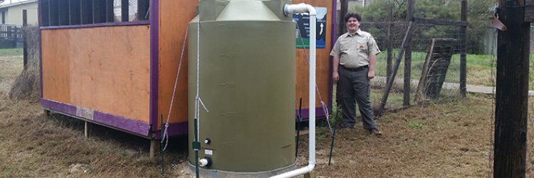 An Eagle Scout stands at Paredes Middle School after a beautification project.