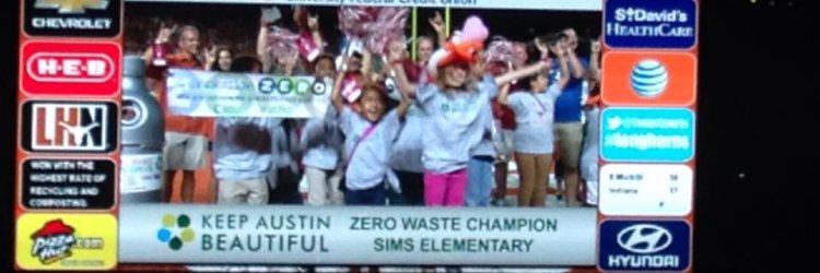 Photo of Keep Austin Beautiful volunteers on the TV at a UT football game.